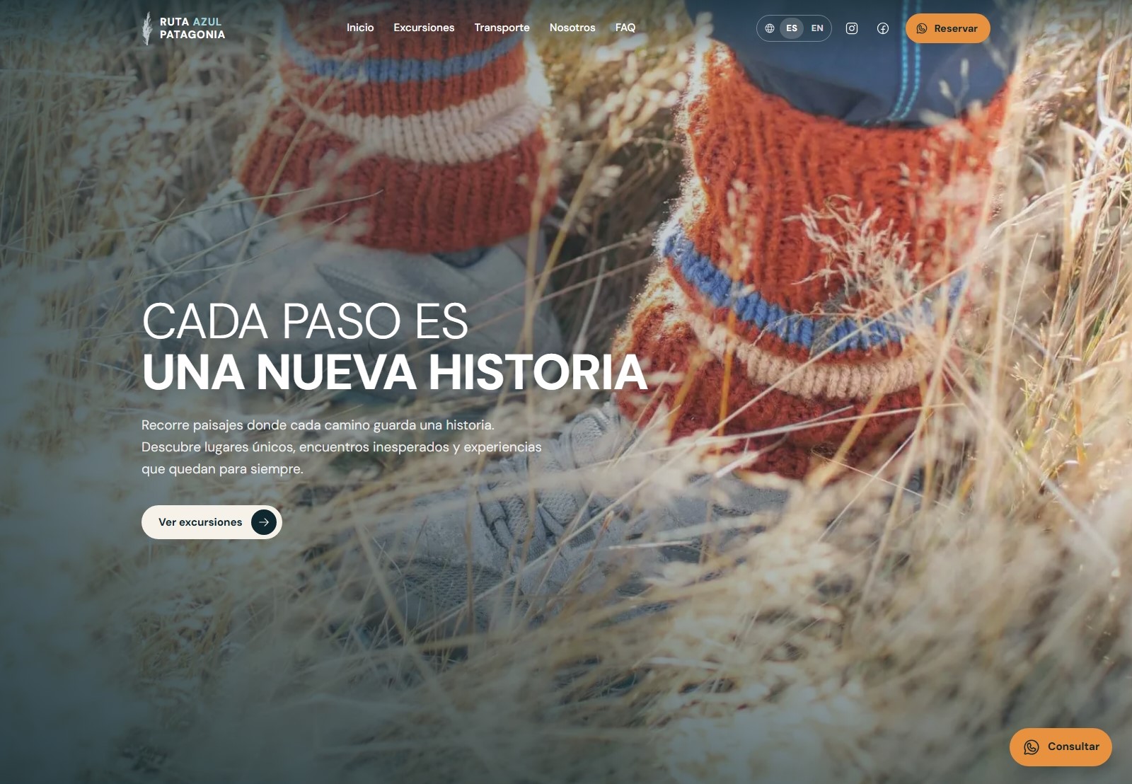 Ruta Azul Patagonia homepage featuring the San Isidro lighthouse adventure, with two hikers on a rocky shoreline beside the Strait of Magellan.